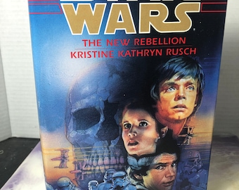 May include: A Star Wars paperback book cover featuring a blue and white background with a skull, Luke Skywalker, Princess Leia, Han Solo, and Stormtroopers. The title "Star Wars" is in gold lettering and the subtitle is "The New Rebellion Kristine Kathryn Rusch".