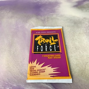 May include: A purple and yellow card pack with the text "STAR PICS PRESENTS TROLL FORCE" and "7 COLLECTIBLE CARDS PLUS 1 STICKER". The pack also has the text "LOOK FOR TROLL FORCE™ COMIC STRIP CARDS!!!".
