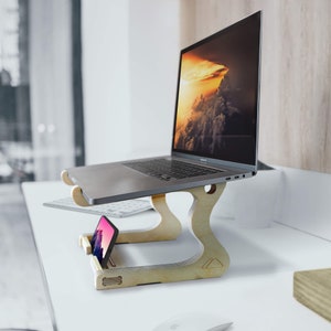 May include: A wooden laptop stand with a laptop and a smartphone on it. The laptop is open and has a screen displaying a landscape image of clouds and a sunset. The stand is made of light wood and has a simple design.