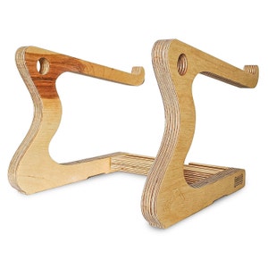 May include: A wooden laptop stand with a natural finish. The stand is made of plywood and has a unique curved design. It is designed to elevate a laptop to a comfortable viewing height.