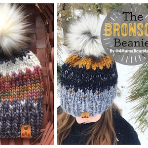 May include: A gray, black, and mustard yellow knit beanie with a white faux fur pom pom. The beanie has a brown leather patch with a mountain logo. The beanie is called "The Bronson Beanie" by @4MamaBearMade.