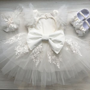 Elfenbeinfarbenes Kleid aus Spitze und Tüll mit Haarband und Höschen mit Perlen und Schleife. Outfit für Geburtstag, Taufe oder Blumenmädchen.