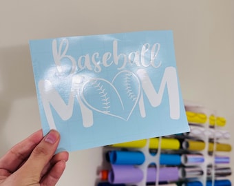 May include: A light blue sheet of vinyl with a white design that says "Baseball Mom" with a baseball in a heart shape.