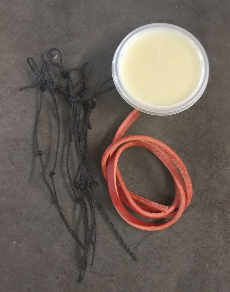 May include: A small container of white leather conditioner, a red leather cord, and a bundle of black cords.