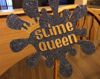 May include: A black glitter slime-shaped sign with a gold crown and the text "slime queen".