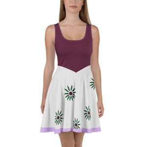 Könnte beinhalten: Ein ärmelloses Kleid mit einem einfarbigen, dunkelweinroten Oberteil mit Rundhalsausschnitt und einem weißen, ausgestellten Rock. Der Rock ist mit einem wiederkehrenden Muster aus dunkelgrünen, gänseblümchenartigen Blüten mit weinroter Mitte verziert.