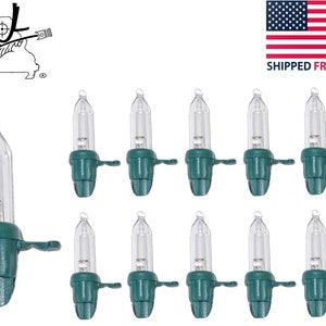 May include: A collection of clear mini Christmas light bulbs with green bases. The bulbs are small, with a clear glass exterior and a small filament inside. The green bases have a small tab on the side. The image also includes a logo and an American flag.