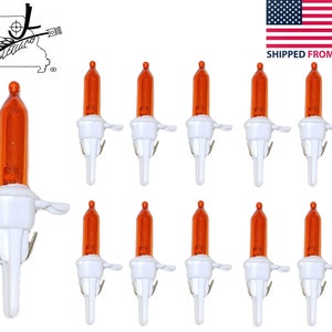May include: Ten orange Christmas lights with white clips. The lights are small and have a clear bulb.