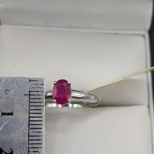 May include: A white ceramic mug with a black handle and the text "But First, Coffee" in a bold, black font. The mug is set against a blurred background, suggesting a cozy setting. The mug appears to be approximately 4 inches tall.