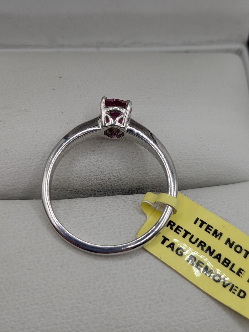 May include: A white ceramic mug with a black handle and the text "But First, Coffee" in a bold, black font. The mug is set against a blurred background, suggesting a cozy setting.