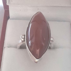 May include: A silver ring with a brown marquise-shaped gemstone.