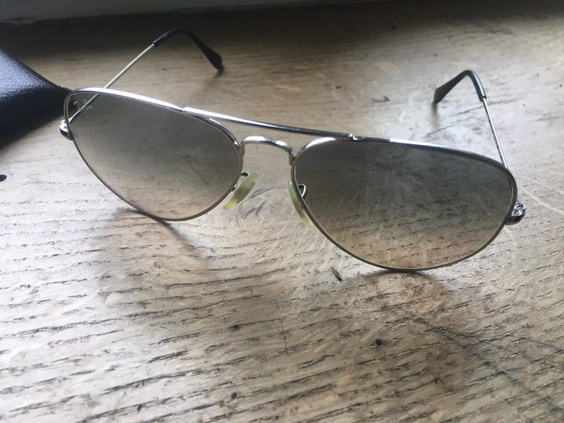 K&ouml;nnte beinhalten: Silberne Aviator-Sonnenbrille mit grauen Verlaufsgl&auml;sern.