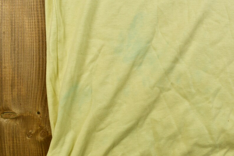 K&ouml;nnte beinhalten: Ein blassgelber Stoff mit einem hellblauen Fleck.