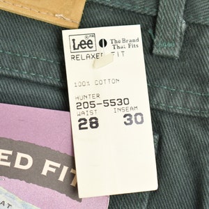 May include: A green pair of Lee Relaxed Fit jeans with a white tag that reads "Lee The Brand That Fits Relaxed Fit 100% Cotton Hunter 205-5530 Waist 28 Inseam 30".