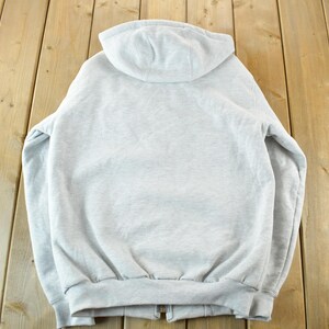 Puede incluir: Sudadera con capucha gris claro con cierre de cremallera completo. La vista trasera de la sudadera muestra la capucha, la cremallera y el dobladillo y los pu&ntilde;os de canal&eacute;. La sudadera est&aacute; hecha de un material suave y c&oacute;modo.