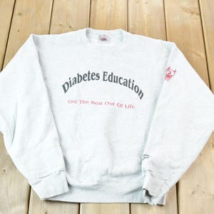 May include: Grey sweatshirt with the text "Diabetes Education Get The Best Out Of Life" in black lettering.