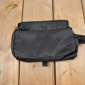 Op de afbeelding: Een zwarte toilettas met rits en een handvat. De tas is gemaakt van waterafstotend nylon.