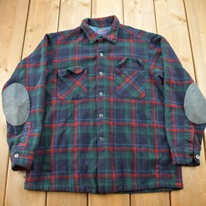 May include: A long-sleeved plaid flannel shirt with elbow patches. The shirt is green, red, and blue.