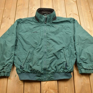 May include: A green fleece-lined jacket with a zipper closure and a black collar. The jacket has a Columbia logo on the left chest.