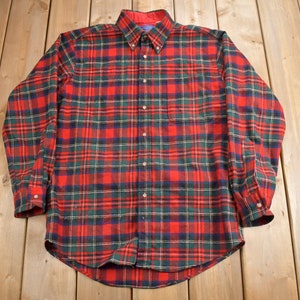 May include: A red, green, and blue plaid long-sleeve button-down shirt.