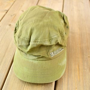 May include: A green Kangol brand baseball cap with a slightly distressed look.