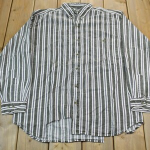May include: A long-sleeved button-down shirt with white and dark grey vertical stripes. The shirt has a single chest pocket and a button-up collar.