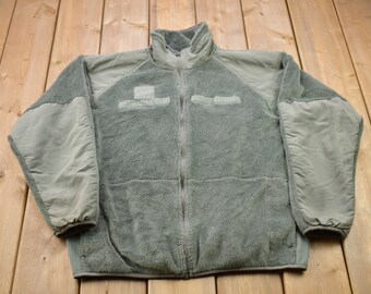 May include: A green fleece jacket with a zipper closure and two pockets on the chest. The jacket has a high collar and is made of a soft, warm material.