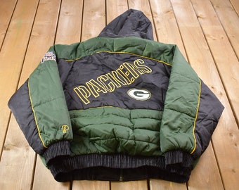 May include: Green and black padded jacket with a large "Packers" logo on the back. The jacket has a hood and a zip closure.