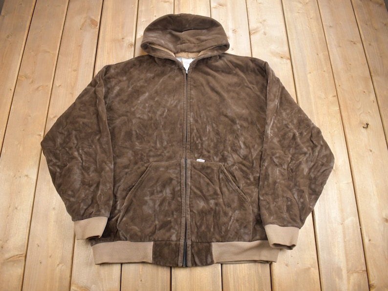 May include: A brown corduroy hooded sweatshirt with a zipper closure. The sweatshirt has a tan colored lining and a tan colored waistband.