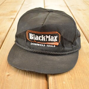 Può includere: Cappellino da baseball nero con visiera curva e dettaglio a corda. Il cappellino presenta la scritta "BlackMax DOWNHOLE TOOLS" in bianco e arancione sul davanti.