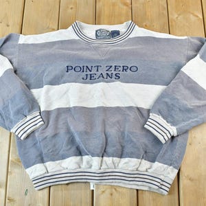 May include: A gray and white striped sweatshirt with the text "POINT ZERO JEANS" embroidered on the front.