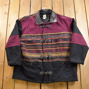 May include: A black and burgundy jacket with a southwestern patterned design. The jacket has a leather collar and toggle closures.