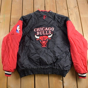May include: Black and red reversible jacket with the Chicago Bulls logo and the NBA logo on the sleeve. The jacket has a black zipper and a black elastic waistband.