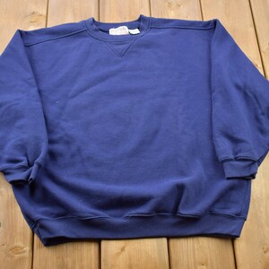 May include: A solid navy blue sweatshirt with a crew neck.