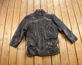 May include: A brown leather jacket with a zipper closure, multiple pockets, and a stand-up collar.