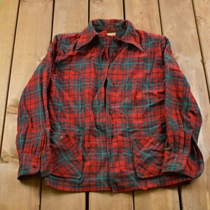 May include: A red and green plaid long-sleeved shirt with two front pockets.