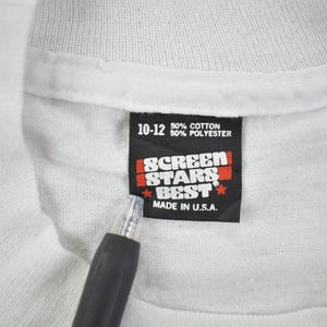 May include: White tag with black text that reads "10-12 50% cotton 50% polyester" and "Screen Stars Best Made in U.S.A."