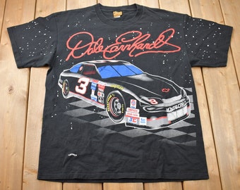 May include: Black t-shirt with a white and black checkered pattern, a black race car with the number 3 on the side, and the signature "Dale Earnhardt" in red.