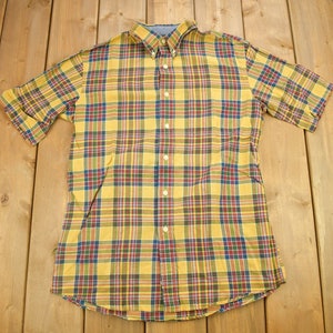 Peut inclure: Une chemise à manches courtes à boutons, à carreaux jaunes, rouges, bleus et verts.