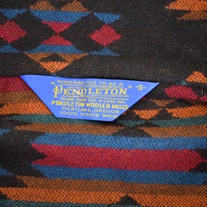 May include: A trio of cream-glazed ceramic mugs, each adorned with a hand-painted floral pattern in blue, green, and yellow hues. The mugs have a rounded form and a handle, ideal for enjoying a warm beverage.