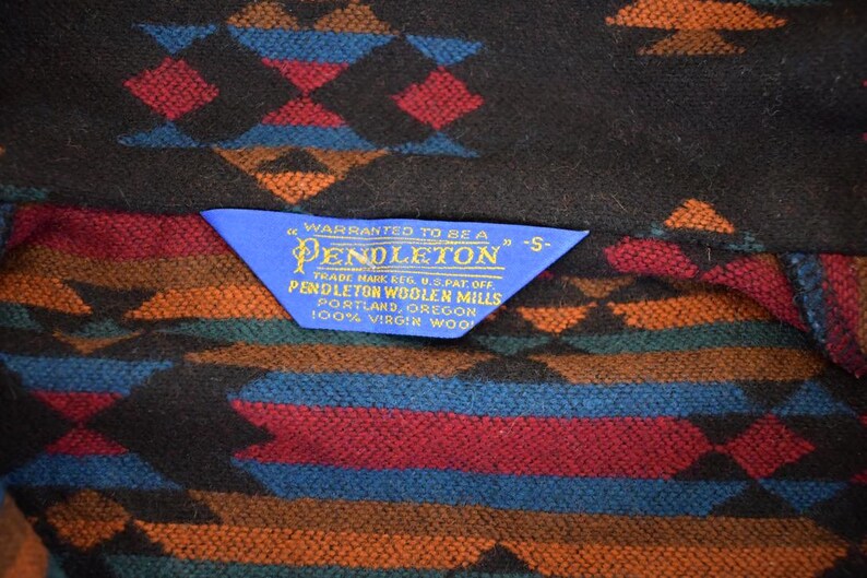 May include: A trio of cream-glazed ceramic mugs, each adorned with a hand-painted floral pattern in blue, green, and yellow hues. The mugs have a rounded form and a handle, ideal for enjoying a warm beverage.