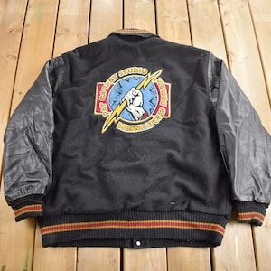 May include: Black varsity jacket with leather sleeves and a large embroidered patch on the back that says "First Avenue Studio Records Minneapolis".