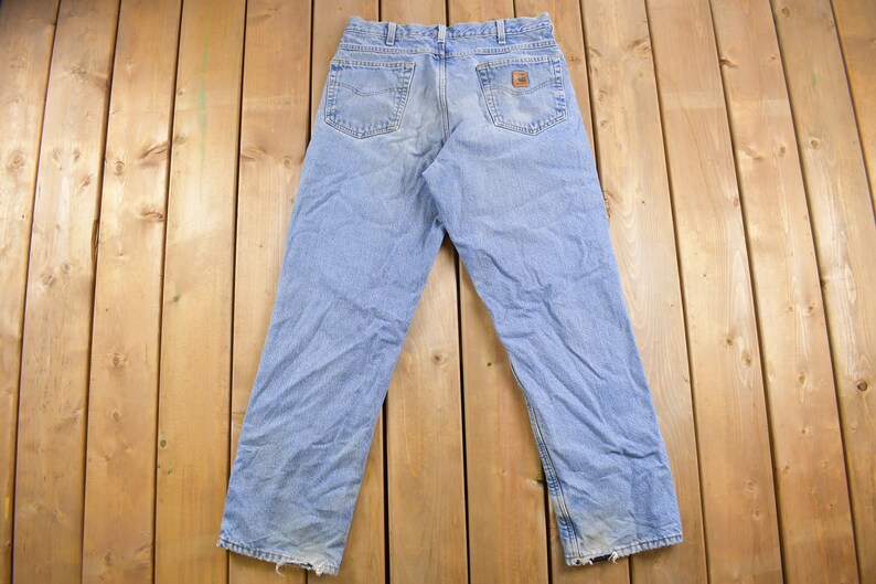 May include: A pair of light blue denim jeans with a brown leather patch on the back pocket.