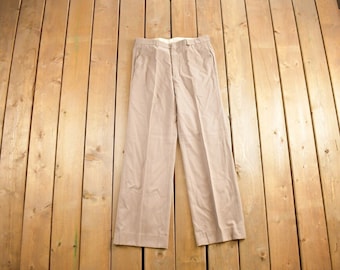 May include: A pair of light brown pants with a straight leg and a flat front.