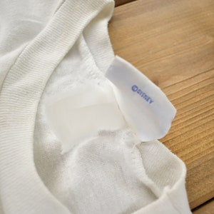 May include: White t-shirt with a white tag and a blue "DISNEY" label.
