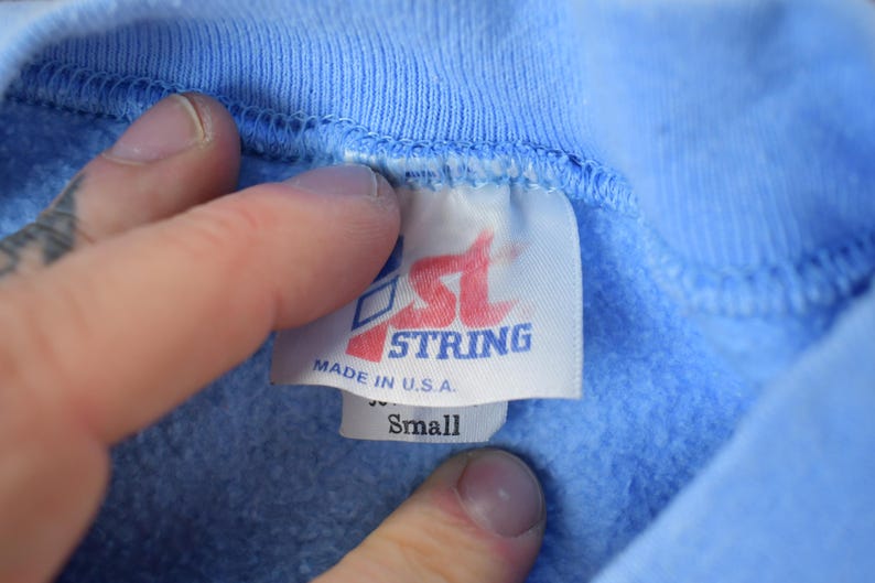 May include: A blue sweatshirt with a white tag that says "1st String Made in U.S.A. Small"