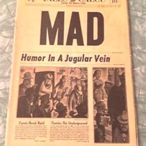 Puede incluir: Una portada de revista vintage con el título "MAD" en letras negras en negrita. La portada presenta una ilustración en blanco y negro de un hombre con una cabeza grande y una expresión de sorpresa. El texto "Humor In A Jugular Vein" está debajo del título. La portada también incluye el texto "Comic-Book Raid" y "Comics Go Underground".