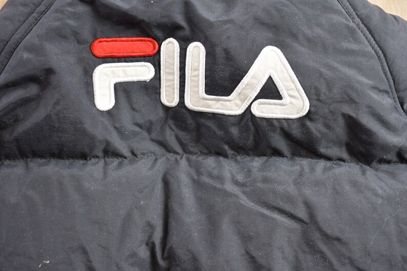 May include: Black puffer jacket with a white and red FILA logo.