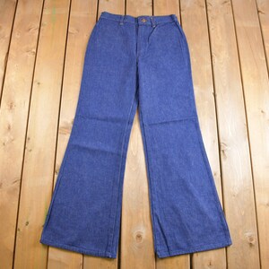 Op de afbeelding: Een paar blauwe denim bellbottom broek met een hoge taille en een knoopsluiting.