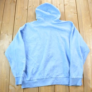 May include: A light blue hooded sweatshirt with long sleeves. The sweatshirt is made of a soft, comfortable fabric.
